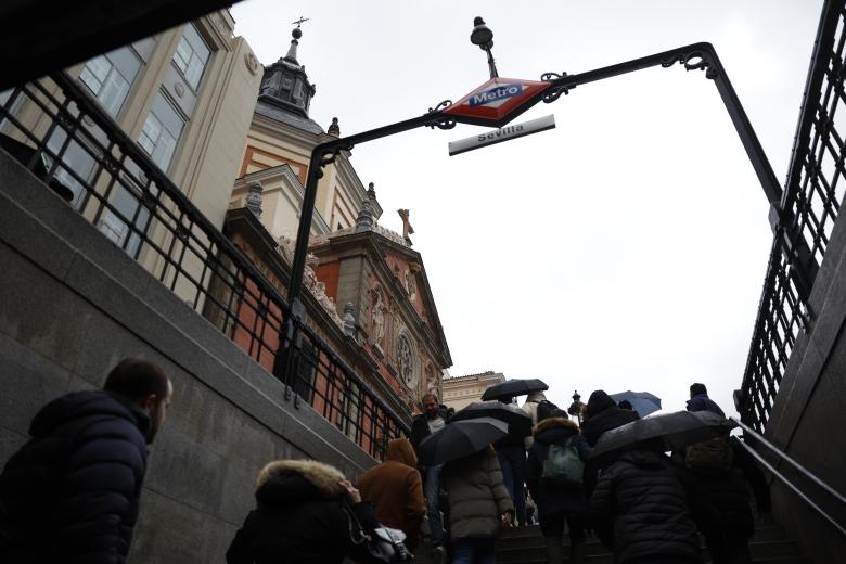 La gente sale con paraguas de la estación de Metro de Sevilla en el centro de Madrid este sábado. El paso de la borrasca Nelson ha mantenido en alerta amarilla por precipitaciones, viento fuerte y fenómenos costeros a diferentes provincias andaluzas a lo largo del fin de semana.