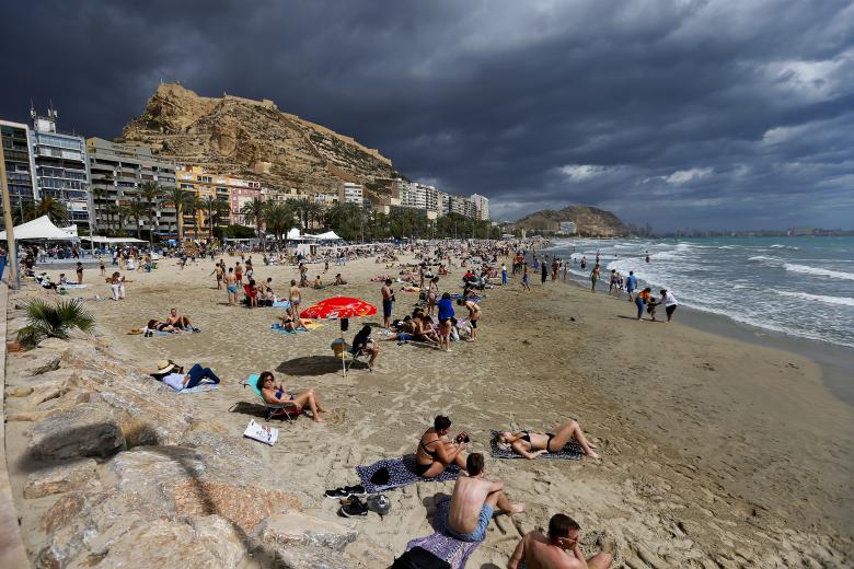 Centenares de turistas disfrutaron este pasado Jueves Santo en la playa del Postiguet en Alicante.