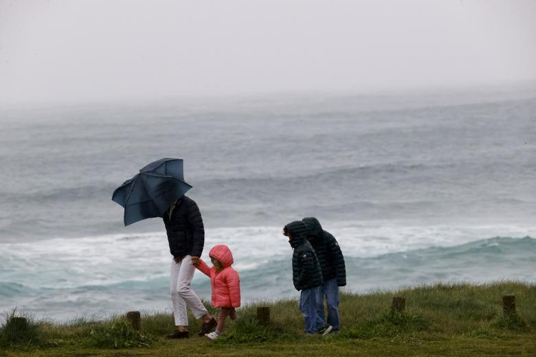 Una familia pasea por la costa de Ferrol este pasado miércoles. Los días festivos de Semana Santa han estado dominados por la borrasca Nelson que va a dejar fuertes rachas de viento, nieve, mal estado de la mar y sobre todo lluvias en casi toda la península.