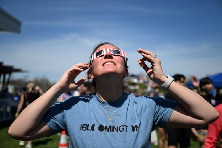 Varias personas observan el eclipse solar total en desarrollo en Bloomington, Indiana.