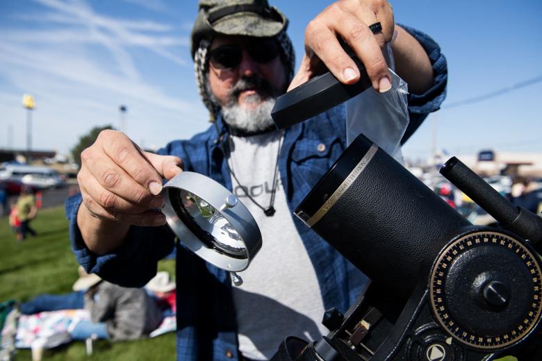 Una persona prepara su telescopio para ver el eclipse solar en el Museo del Aire y el Espacio Neil Armstrong en Ohio