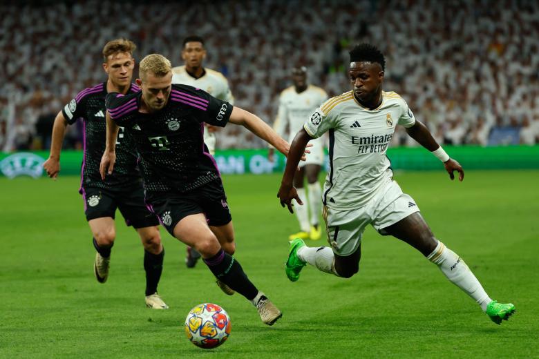 MADRID, 08/05/2024.- El delantero brasileño del Real Madrid, Vinicius Junior (d), disputa el balón ante el defensa neerlandés del Bayern de Munich, Matthijs De Ligt, durante el encuentro correspondiente a la vuelta de las semifinales de la Liga de Campeones que disputan hoy miércoles Real Madrid y Bayern de Munich en el estadio Santiago Bernabéu, en Madrid. EFE / Mariscal.