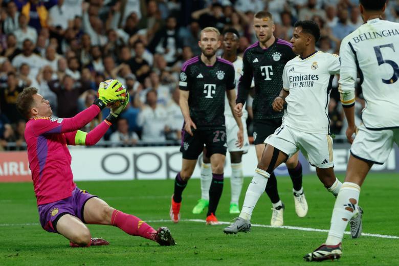 MADRID, 08/05/2024.- El portero del Bayern, Manuel Neuer (i), detiene un balón ante Rodrygo Goes (d), del Real Madrid, durante el partido de vuelta de las semifinales de la Liga de Campeones que Real Madrid y Bayern de Múnich disputan hoy miércoles en el estadio Santiago Bernabéu. EFE/Mariscal