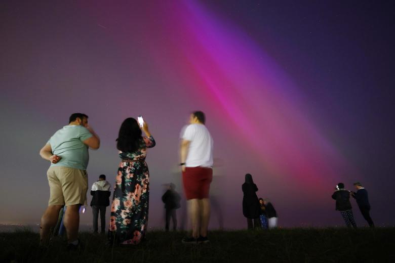 Gente disfrutando de la aurora boreal en Gran Bretaña