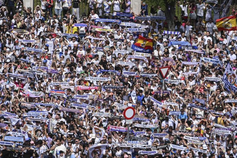 Aficionados del Real Madrid celebran con el equipo la trigésimo sexta Liga, este domingo en la plaza de Cibeles