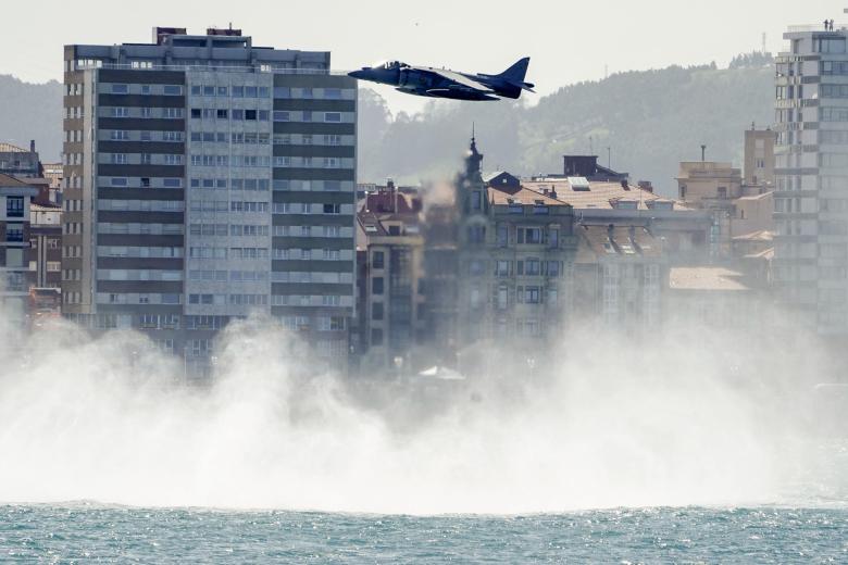 Un caza de combate Harrier, embarcado en el portaaeronaves L-61 Juan Carlos I, muestra su poderío en la playa de San Lorenzo de Gijón. Este mítico caza tiene la capacidad de despegar y aterrizar en vertical