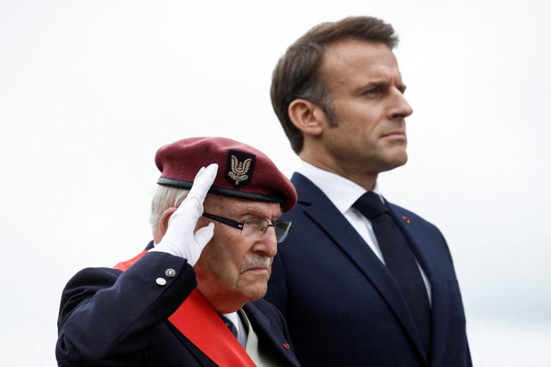 Achille Muller (L), 98, last survivor of the Free French Forces, salutes beside France's President Emmanuel Macron (R) as they attend a ceremony commemorating SAS paratroopers and Free French Forces who died in Brittany during World War II, at La Gree mill SAS (Special Air Service) memorial in Plumelec, western France, on June 5, 2024, as part of the "D-Day" commemorations marking the 80th anniversary of the World War II Allied landings in Normandy. The D-Day ceremonies on June 6 this year mark the 80th anniversary since the launch of 'Operation Overlord', a vast military operation by Allied forces in Normandy, which turned the tide of World War II, eventually leading to the liberation of occupied France and the end of the war against Nazi Germany. (Photo by Benoit Tessier / POOL / AFP)
