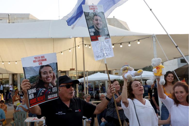 Los israelíes celebran con carteles en los que se lee «Home Now» (A casa ya) los retratos de dos de los cuatro rehenes israelíes