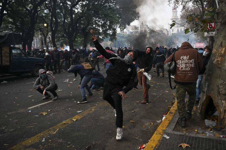 Los manifestantes arrojan piedras contra los policías antidisturbios que resguardan el Congreso argentino