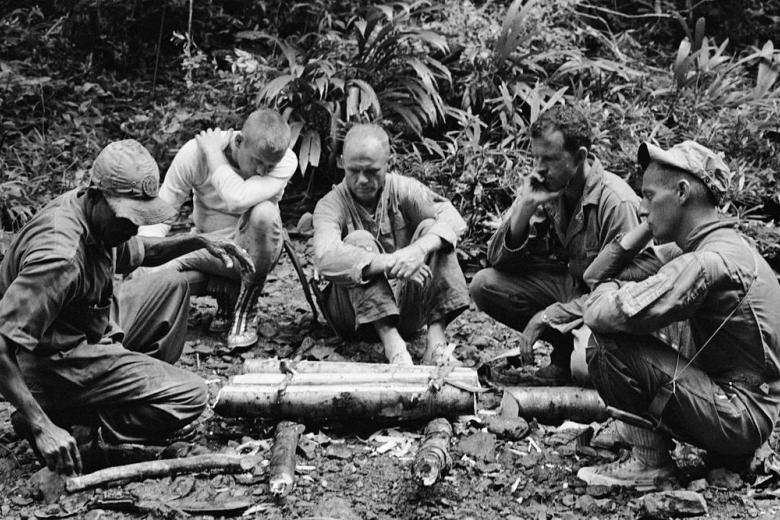 Algunos de los dieciséis astronautas de la NASA participan en un entrenamiento de supervivencia tropical desde el 3 al 6 de junio de 1963 en la Base de la Fuerza Aérea de Albrook, Zona del Canal. De izquierda a derecha están el entrenador no identificado, Neil Armstrong, John H. Glenn, Jr., L. Gordon Cooper y Pete Conrad