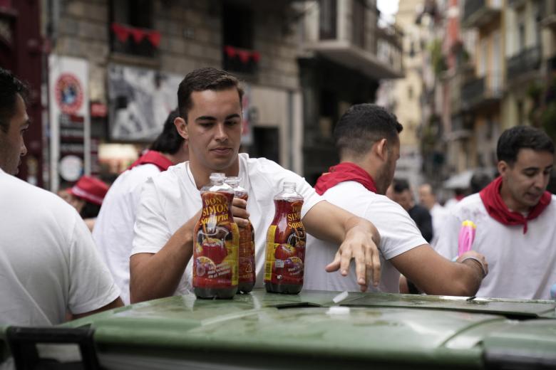 Varias personas beben tinto de verano los minutos previos al chupinazo