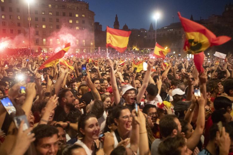 Banderas de España y botes de humo rojo en la Plaza de Cataluña, en Barcelona