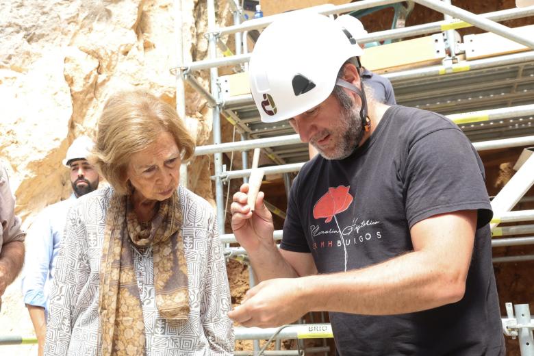 La Reina contempla el trabajo de un científico en los yacimientos de Atapuerca