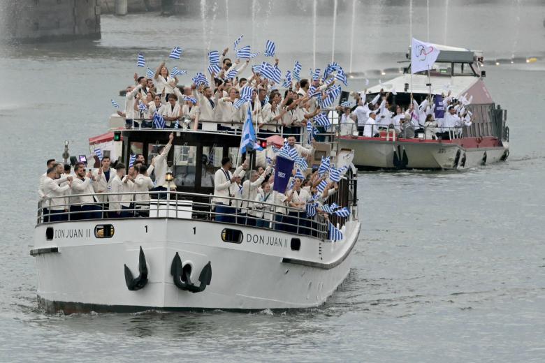 Athletes from Greece's delegation sail in a boat under Austerlitz bridge along the river Seine at the start of the opening ceremony of the Paris 2024 Olympic Games in Paris on July 26, 2024. (Photo by Aris MESSINIS / AFP)