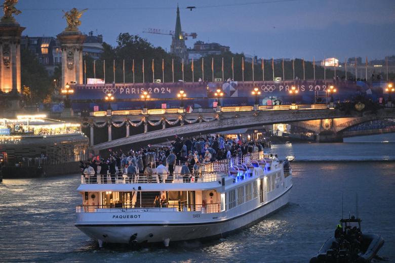 Los atletas de la delegación francesa navegan en un barco por el río Sena durante la ceremonia de apertura de los Juegos Olímpicos de París 2024