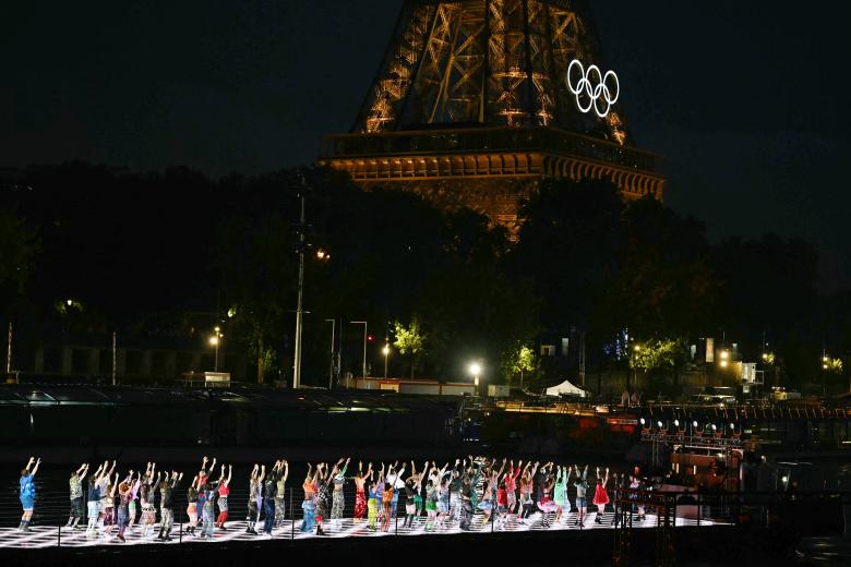 Artistas bailan en un espectáculo en un barco que navega por el río Sena cerca de la Torre Eiffel