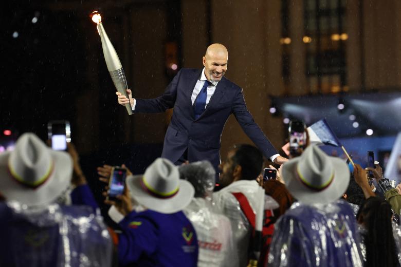 El exfutbolista francés Zinedine Zidane lleva la llama olímpica en el Trocadero durante la ceremonia de apertura de los Juegos Olímpicos de París 2024 en París el 26 de julio de 2024