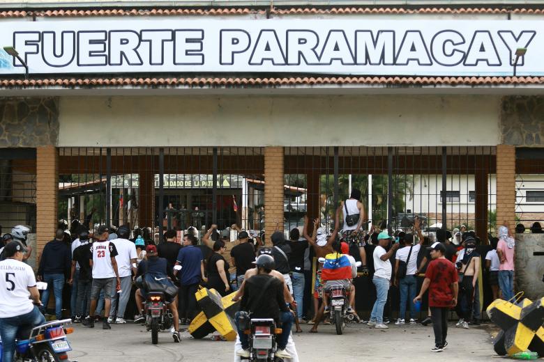 Manifestantes se reúnen en la entrada de la 41 Brigada Blindada, conocida como Fuerte Paramacay, durante una protesta contra el gobierno