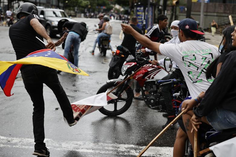 Una persona patea un cartel con la imagen del presidente de Venezuela, Nicolás Maduro, durante una protesta por los resultados de las elecciones presidenciales este lunes, en Caracas