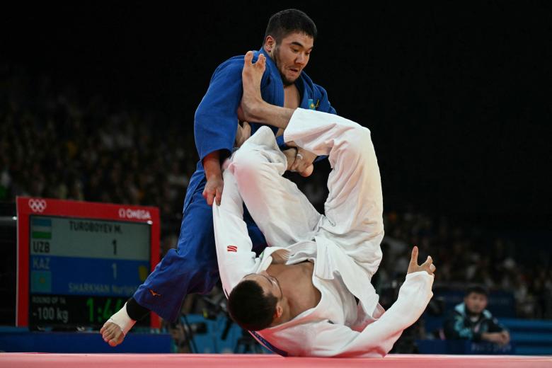 Muzaffarbek Turoboyev de Uzbekistán y Nurlykhan Sharkhan de Kazajstán compiten en el combate de octavos de final de judo masculino de -100 kg de los Juegos Olímpicos de París