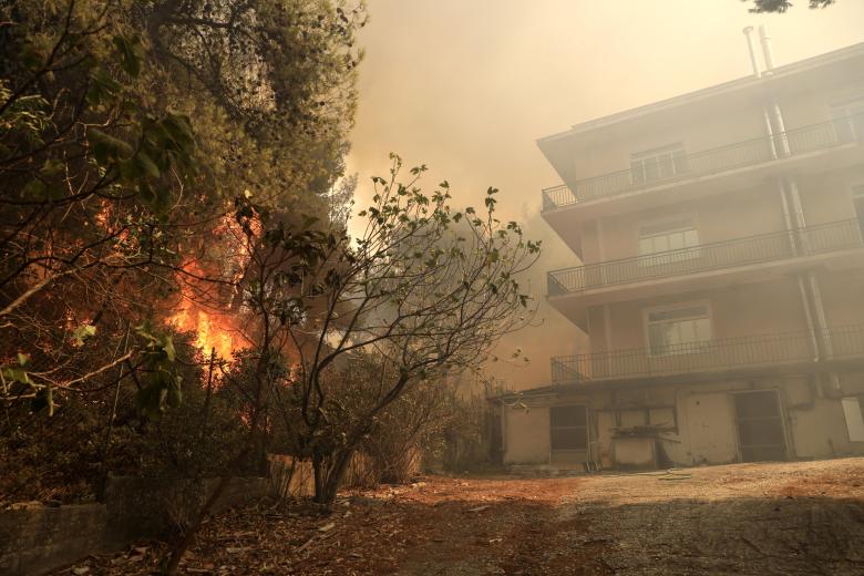 Las llamas rodean un edificio en Patima Halandri, un suburbio de Atenas