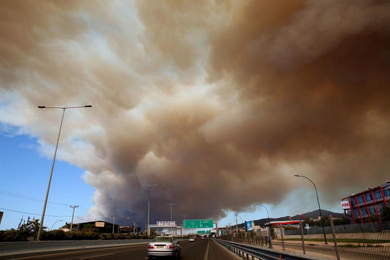 Un humo espeso cubre una carretera en Atenas debido a un incendio forestal que estalló en la zona agrícola en Varnavas