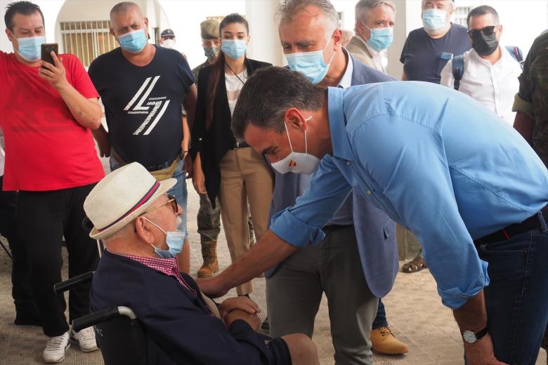 El presidente del Gobierno, Pedro Sánchez, conversa con un vecino durante su visita al Centro de acogida de afectados por la emergencia volcánica, ubicado en el Acuartelamiento de El Fuerte