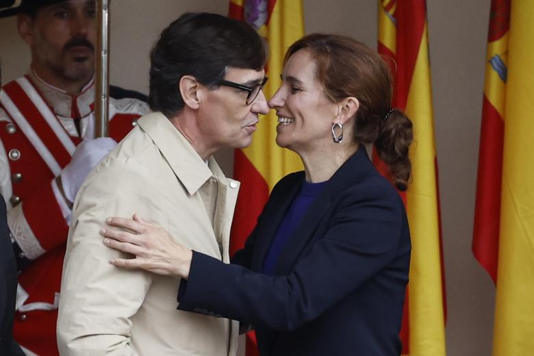 La ministra de Sanidad, Mónica García, saluda al presidente de la Generalitat de Cataluña y extitular de la cartera que ella lidera, Salvador Illa