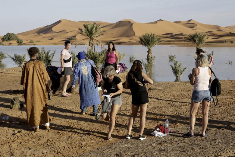 Los turistas visitan el lago Yasmina, un lago estacional en el pueblo de Merzouga en el desierto del Sahara en el sureste de Marruecos el 20 de octubre de 2024