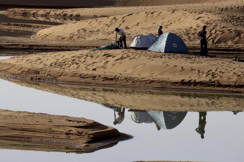 Los turistas acampan a los pies de uno de los lagos formados por las lluvias