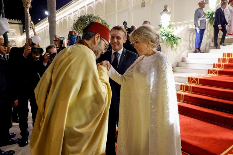 Morocco's King Mohammed VI (L) kisses the hand of French President's wife Brigitte Macron (R), next to France's President Emmanuel Macron (C), as they arrive at the Royal Palace for a state dinner in Rabat on October 29, 2024, as part of a three-day state visit by France's President to Morocco. Photo by Ludovic Marin/Pool/ABACAPRESS.COM