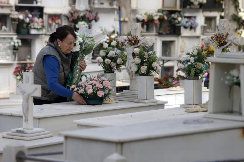 Una persona visita y arregla una tumba en el cementerio de la barriada de El Palo (Málaga) en el Día de Todos los Santos