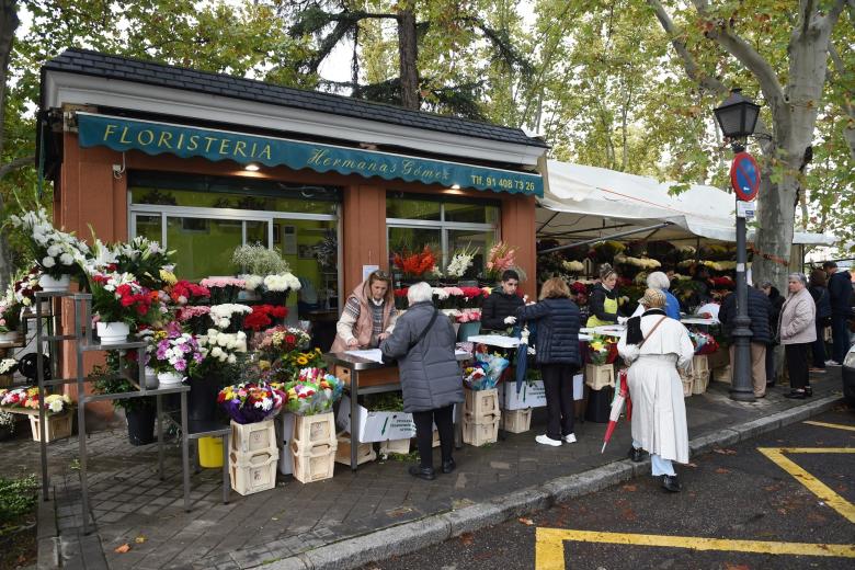 Varias personas compran flores en el Cementerio de la Almudena