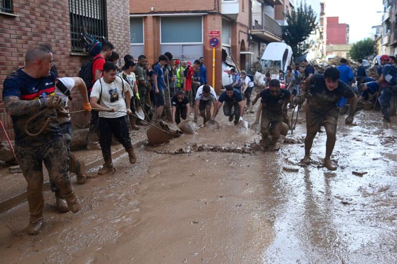 Locales y voluntarios retiran lodo después de que las lluvias devastaran Paiporta. Hay zonas donde todavía no han podido entrar los equipos de emergencias.