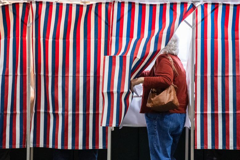 Una persona ingresa a una cabina de votación en un centro de votación en Colebrook Academy and Elementary School en Colebrook, New Hampshire