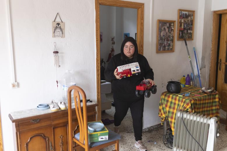 Una vecina de Coín (Málaga) recoge algunos juguetes preferidos de su hermana antes de ir a casa de su vecino por el posible derribo del muro trasero de su vivienda