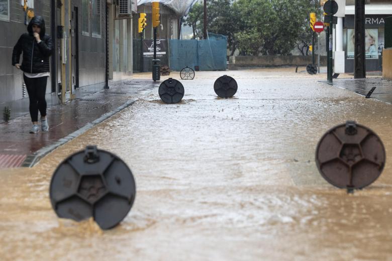 Cantarillas abiertas en una calle de la barriada de Campanillas en Málaga, en la que el paso de la dana ha obligado a nuevos desalojos preventivos en el río Campanillas ante su posible desbordamiento, que se suman a los de 3.000 personas en la ribera del Guadalhorce.