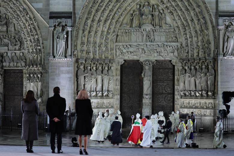 El presidente francés Emmanuel Macron (2-L) y su esposa Brigitte (3-L) observan al arzobispo de París Laurent Ulrich inaugurando la Catedral de Notre Dame de París llamando a las puertas antes de su ceremonia de reapertura