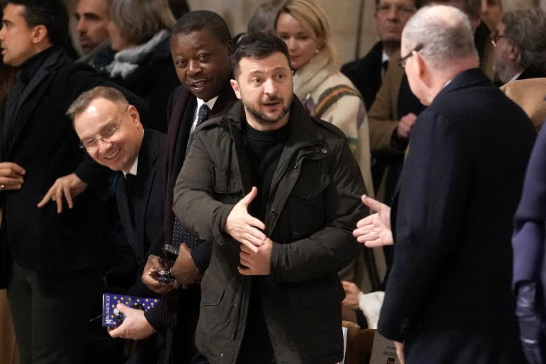 El presidente ucraniano Volodimir Zelenski le da la mano a un invitado dentro de la catedral de Notre Dame de París durante su ceremonia oficial de reapertura