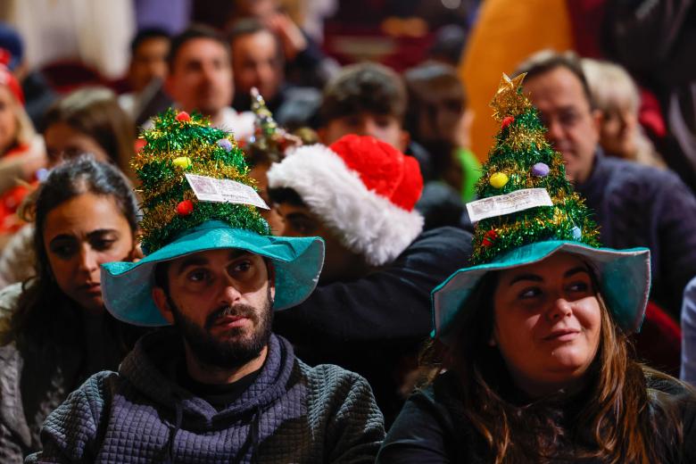 Asistentes aguardan el inicio del sorteo de la Lotería de Navidad este domingo en el Teatro Real, en Madrid