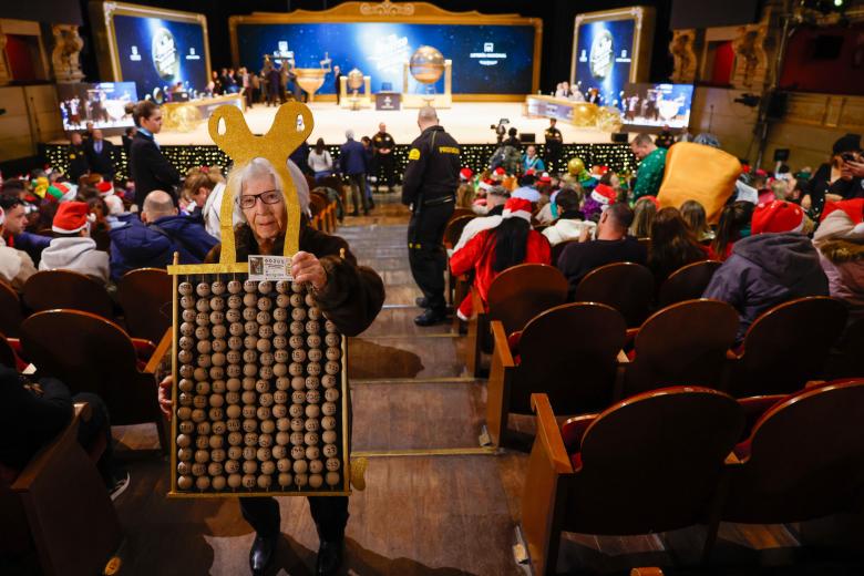 Asistentes aguardan el inicio del sorteo de la Lotería de Navidad este domingo en el Teatro Real, en Madrid