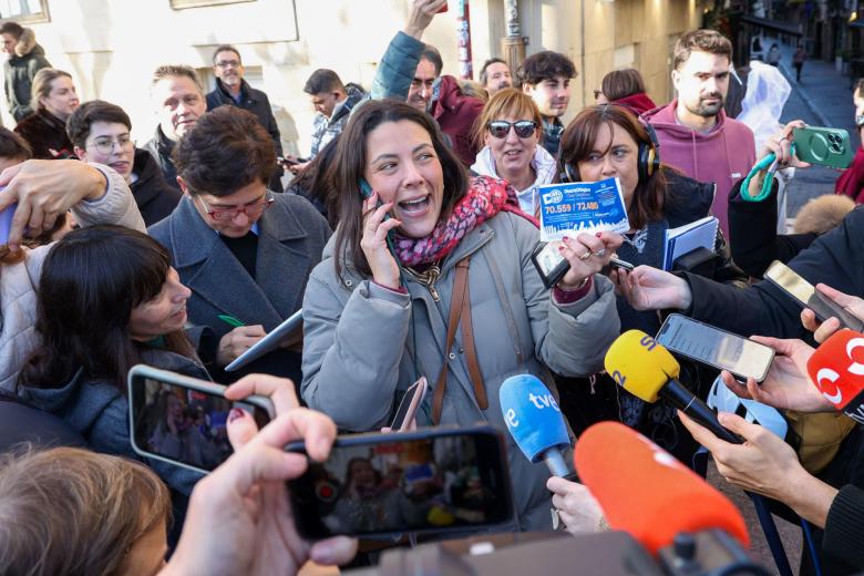 Una agraciada con una participación del Gordo de la Lotería de Navidad rodeada de medios a las puertas de la administración número 6 de Logroño, conocida como Lotería María del Carmen, que ha vendido íntegramente el premio de El Gordo de la Lotería de Navidad