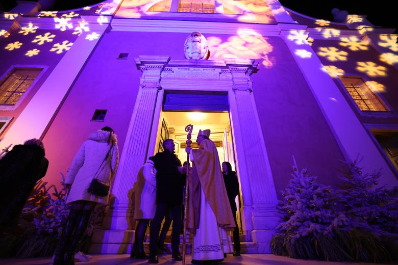 Una pareja musulmana junto a la hoguera ante el santuario de la Virgen María durante el servicio de Nochebuena en la catedral católica siríaca del Sagrado Corazón en la ciudad meridional iraquí de Basora el 24 de diciembre de 2024