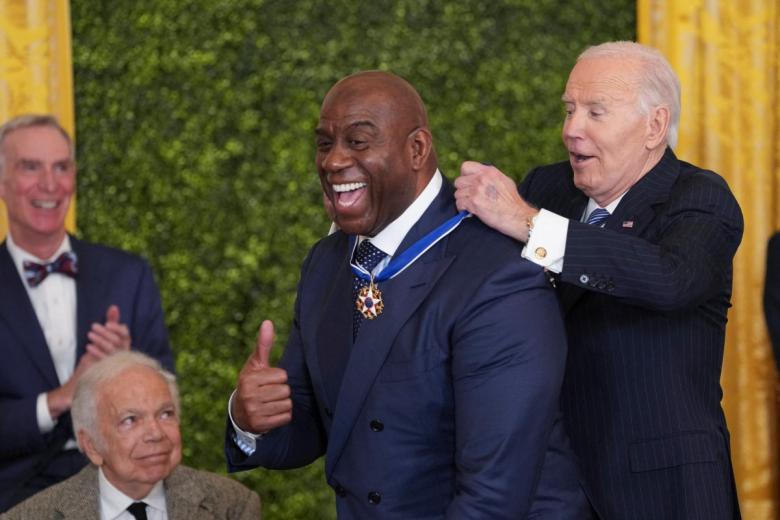 El exjugador de baloncesto 'Magic' Johnson bromea con Joe Biden aprovechando su altura. El presidente tuvo dificultades para colocarle esta distinción