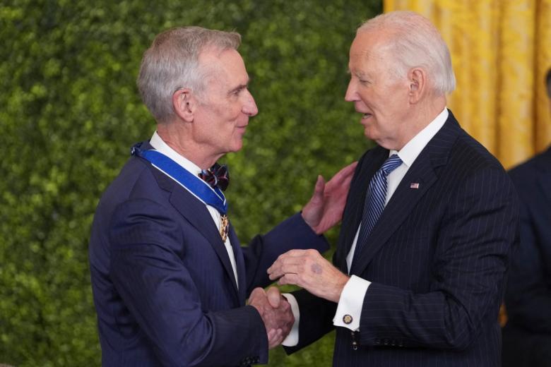 El divulgador científico William Sanford Nye saluda a Joe Biden tras imponerle la medalla