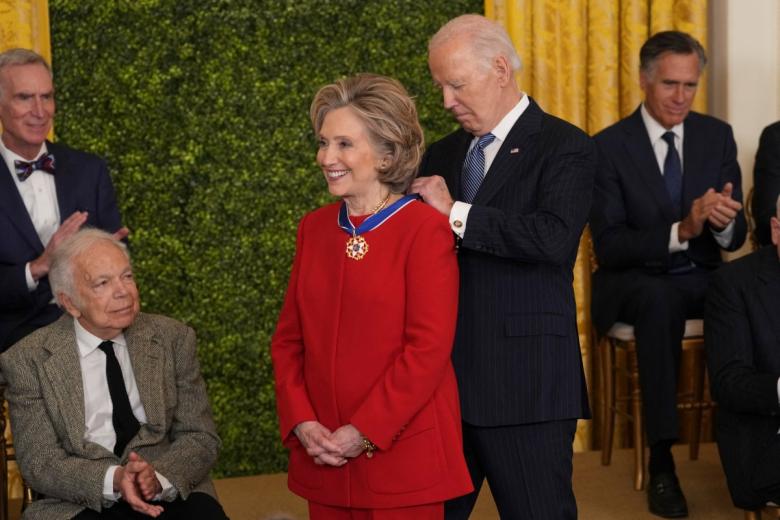 Hillary Clinton, excandidata demócrata a la Casa Blanca, recibe la medalla ante la atenta mirada de Ralph Lauren