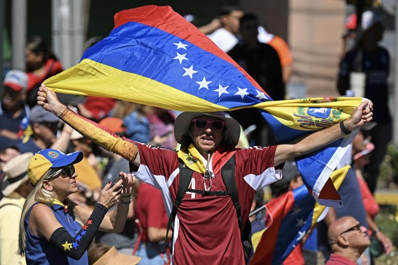 Un manifestante ondea una bandera venezolana durante una protesta convocada por la oposición en vísperas de la toma de posesión presidencial, en Caracas