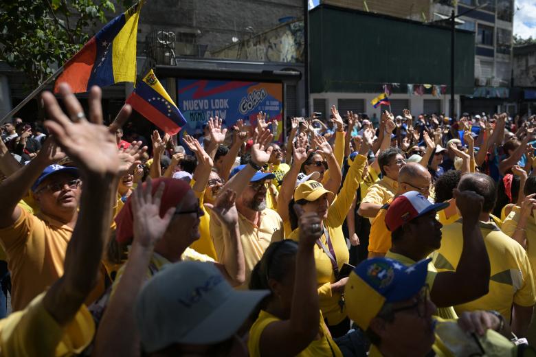 Manifestantes levantan las manos durante la protesta convocada por la oposición en Caracas