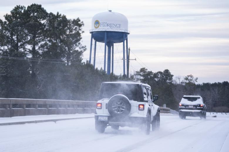 Los automovilistas conducen en la nieve cerca de la I-20 y el intercambio de I-95 el 22 de enero de 2025 en Florencia, Carolina del Sur