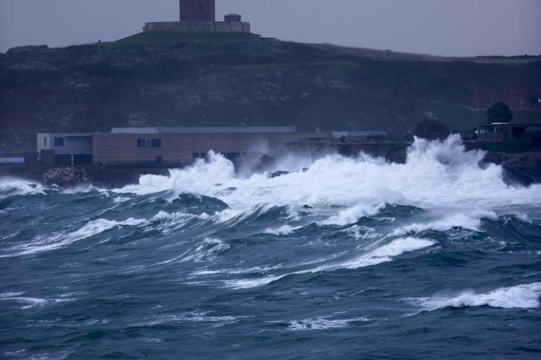 A CORUÑA, 28/01/2025.- Las olas rompían este martes contra la costa de la ciudad de A Coruña, con la Torre de Hércules al fondo, en una jornada en la que la borrasca Herminia continúa afectando a Galicia, con la mayor parte de su litoral en alerta roja, mientras que en el interior los fenómenos meteorológicos comienzan a cesar o a reducir su intensidad. EFE/Cabalar